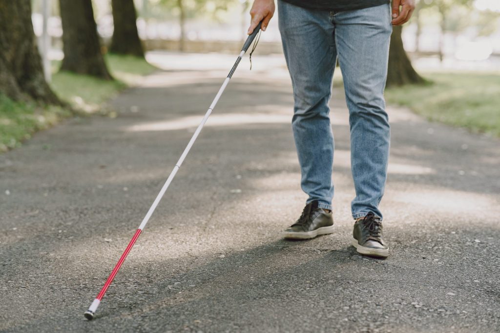 blind man people with disability handicapped person everyday life visually impaired man with walking stick descending steps city park scaled 1